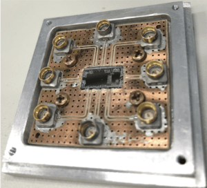 Suporte mecânico com as conexões elétricas para um chip de 8 qubits supercondutores.